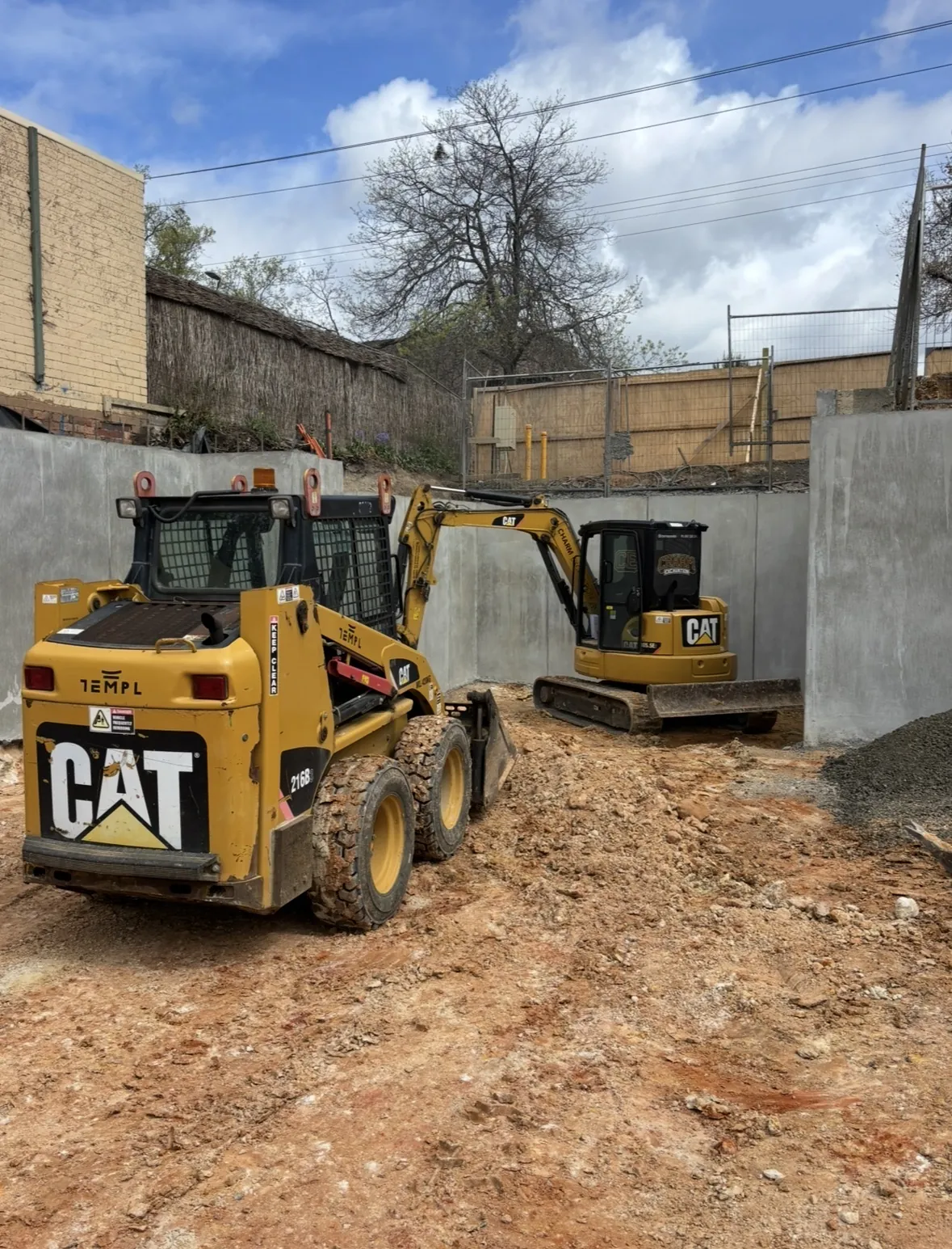 Charm Excavation skidsteer on site during a retaining wall build