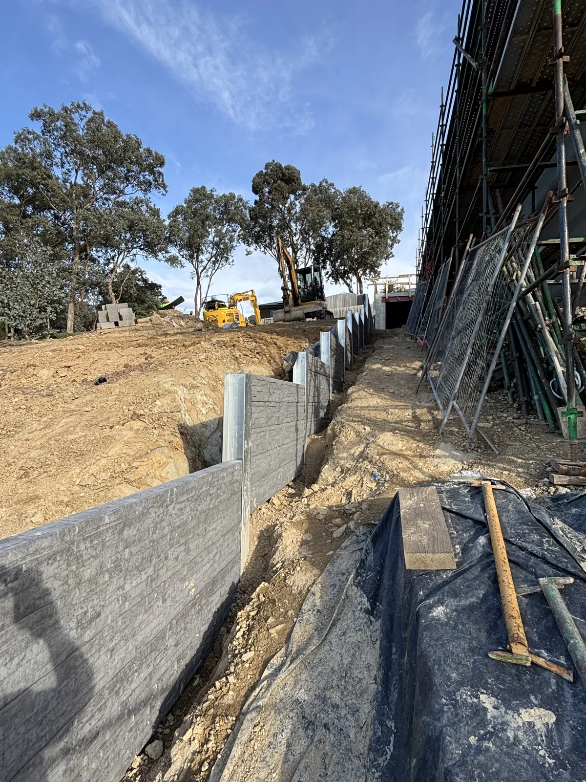 Concrete sleeper retaining wall with drainage membrane during construction in South East Melbourne